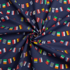 Può includere: Un tessuto blu navy con un motivo ripetitivo di bandiere colorate di diversi paesi. Le bandiere sono disposte in fila e sono collegate da una corda. Il tessuto è piegato al centro, creando un motivo radiale.