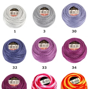 May include: Nine balls of D.M.C. Size 8 Cotton Perle thread in various colors, including white, gray, lavender, blue, purple, magenta, dark pink, variegated pink, and variegated orange, each labeled with a number from 1 to 51.