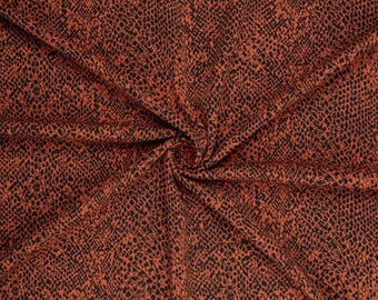 May include: A fabric featuring a repeating black snakeskin pattern printed over a solid burnt orange background. The material is gathered in the center, creating natural folds and drapes that highlight the texture and the detailed animal print.