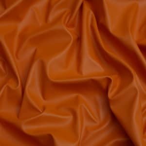 May include: A close-up of a smooth, orange fabric with a soft, wrinkled texture.