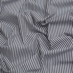 May include: White fabric with black stripes, folded and crumpled, creating a textured background.