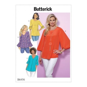 May include: Butterick sewing pattern B6456 featuring four variations of a blouse with bell sleeves. The illustrations show a yellow patterned top, a purple floral top, a turquoise top, and a photograph of a bright orange blouse with white trousers.