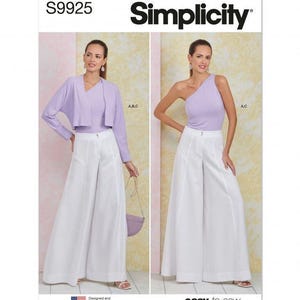 May include: Simplicity sewing pattern S9925 featuring two views of a garment set. View one shows a light purple long-sleeve bolero jacket over a matching top with white wide-leg trousers. View two shows a one-shoulder light purple top with white trousers.