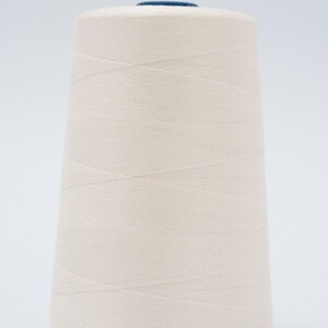 May include: A large, conical spool of off-white thread featuring a smooth, tightly wound texture. The spool has a dark blue circular cap at the top center, and the thread is wrapped in a consistent, crisscross pattern around the entire structure.