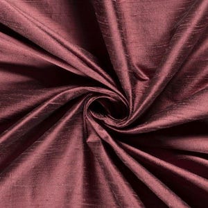 Peut inclure: Un tissu bordeaux profond doté d'une texture flammée distincte et d'un éclat subtil. Le matériau est rassemblé en un tourbillon central, créant des plis et des ombres rayonnants qui soulignent la riche couleur rouge foncé et le tissage irrégulier.