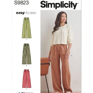 May include: Simplicity sewing pattern S9823 for wide-leg trousers. The envelope features illustrations of three trouser variations in olive green, camouflage, and pink, alongside a photograph of the trousers in a solid rust colour with a high waist.