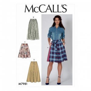 May include: McCall's sewing pattern M7981 showing skirt designs. A woman models a plaid skirt with a button front and a denim shirt. Other skirt styles include floral and plain options. The McCall's logo is at the top.