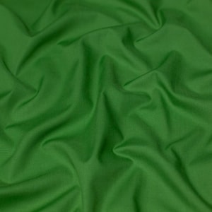 Peut inclure: Un gros plan sur un tissu vert lisse avec des plis et des rides doux.