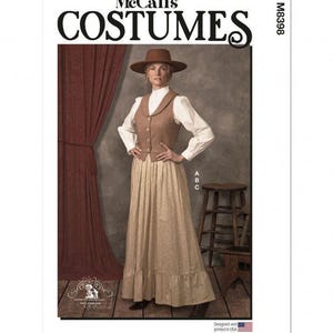 Op de afbeelding: McCall's Costumes patroon M8398 met een bruine hoed, een wit overhemd met lange mouwen, een bruin vest met knoopsluiting en een lange, lichtgekleurde rok met een ruchezoom. De patroonenvelop toont de tekst McCall's COSTUMES en M8398.
