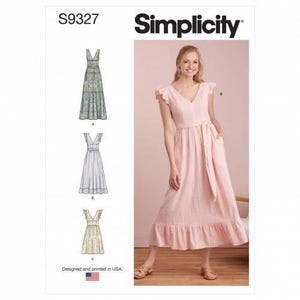 Op de afbeelding: Simplicity naaipatroon S9327 met een lange, lichtroze jurk met V-hals, vlindermouwen en een strikceintuur in de taille. De patroonhoes toont drie variaties van het jurkontwerp, inclusief opties met een bloemenprint en effen kleuren.