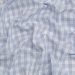 Può includere: Un primo piano di un tessuto gingham blu e bianco con una texture stropicciata.