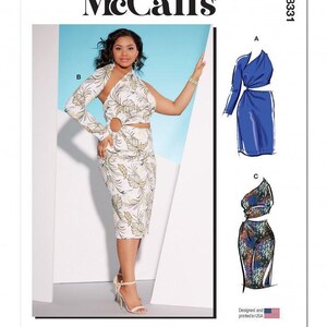 May include: McCall's M8331 sewing pattern envelope featuring a one-shoulder dress with a side cutout and ring detail. The pattern shows three variations: a white dress with a green leaf print, a solid blue dress, and a multi-colored patterned dress.