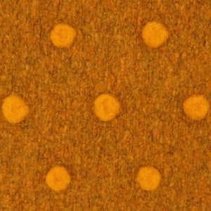 May include: Close-up of a textured fabric in a warm, golden-brown hue. The fabric features a repeating pattern of raised, circular dots in a bright yellow color, creating a tactile and visually appealing design. The dots are evenly spaced across the surface.
