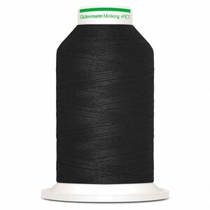 Pode incluir: Um carretel grande de linha de costura preta com uma base branca e uma tampa superior branca. A tampa apresenta uma faixa horizontal verde e o texto impresso Gütermann Miniking rPET. A linha está enrolada firmemente no corpo cilíndrico.