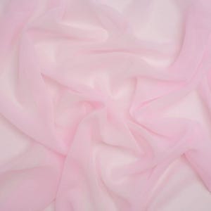 May include: A sheer, light pink fabric with a soft, translucent texture. The material is draped in loose, flowing folds, creating subtle variations in colour intensity and depth across the surface, highlighting its lightweight and delicate nature.