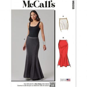 May include: McCall's sewing pattern M8558 featuring a floor-length, dark grey, mermaid-style skirt with a fitted waist and flared hem. The pattern includes illustrations for variations A and B, a QR code for a sew-along tutorial, and text indicating it is designed and printed in the USA.