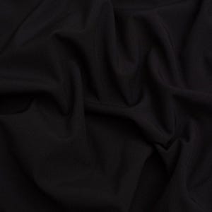 May include: A solid black fabric with a smooth, matte texture, featuring deep, soft folds and natural draping that create subtle shadows and highlights across the surface, emphasising the consistent, dark, and opaque quality of the material.