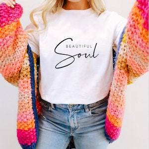 Könnte beinhalten: Weißes T-Shirt mit dem Text "Beautiful Soul" in kursiv.