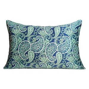 May include: A rectangular throw pillow featuring a dense, intricate paisley pattern in shades of navy blue, teal, and light mint green. The design consists of repeating teardrop-shaped motifs and floral elements covering the entire surface.