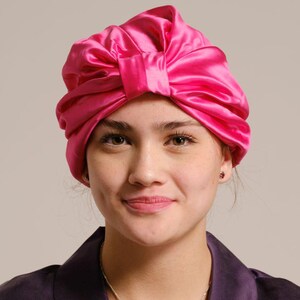 Pu&ograve; includere: Un copricapo da notte in raso rosa con un fiocco in cima. Il copricapo &egrave; progettato per proteggere i capelli durante il sonno.