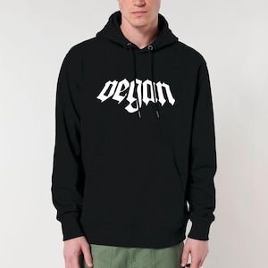 Op de afbeelding: Een zwart hoodie met een witte afbeelding die "vegan" zegt in een gotisch lettertype.