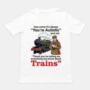 Könnte beinhalten: Ein weißes T-Shirt mit einer Grafik einer Dampflokomotive und einer Person mit Notizblock. Der Text lautet: how come it's always "You're Autistic" and not "Thank you for telling me everything you know about Trains", wobei das Wort Trains rot ist.