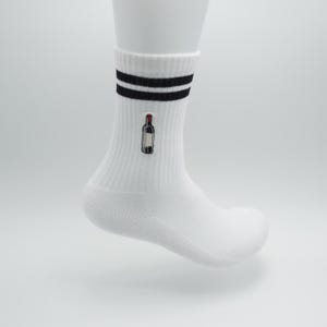 Könnte beinhalten: Weiße Sportsocken mit schwarzen Streifen am oberen Rand und einem kleinen gestickten Weinflaschen-Design. Die Socken sind aus weichem Material und werden auf einem weißen Schaufensterpußenfuß präsentiert.