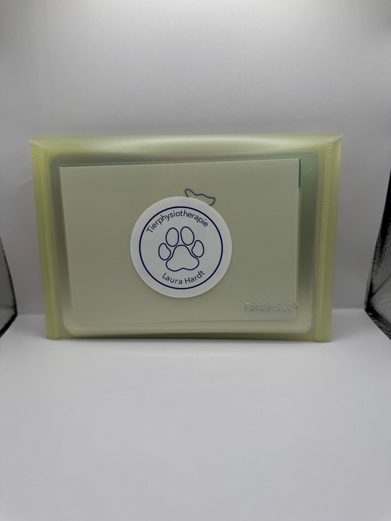 May include: A light green plastic card holder with a white card inside. The card has a blue paw print and the text "Tierphysiotherapie Laura Hardt".