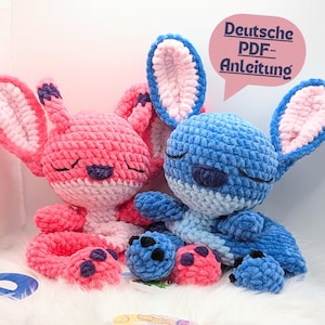 May include: Two handmade crochet plush toys, one pink and one blue, resembling a cartoon character. The toys have large ears, closed eyes, and small, round feet. The pink toy has pink and white accents, while the blue toy has blue and white accents. The image includes the text "Deutsche PDF-Anleitung".