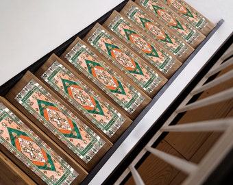 May include: A set of six stair treads with a patterned design featuring orange, green and white colours. The treads are made of wood and have a natural finish.