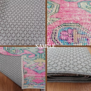 May include: A close-up of a gray rug with a diamond pattern. The rug is folded in half and the edges are visible. The rug is on a wooden surface. The word "SAMPLE" is printed in white on a brown background.