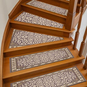 Può includere: Una scala in legno con gradini. I gradini presentano un motivo ripetuto di vortici color crema su uno sfondo viola tenue, incorniciati da un bordo decorativo. La scala è in legno dai toni caldi.