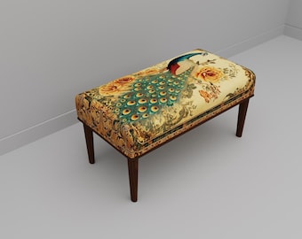 May include: A rectangular bench with four dark brown wooden legs and a cushioned seat upholstered in a cream-colored fabric featuring a detailed peacock illustration, vibrant blue and green plumage, and large orange floral accents.