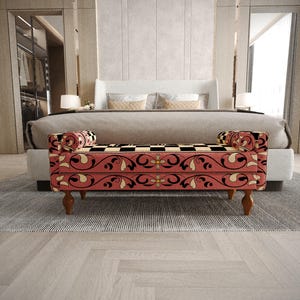 a modern bedroom with a large bed, a red and black patterned bench, and a gray and white rug on the floor.