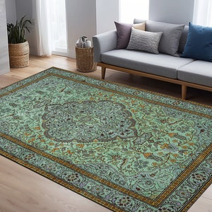 May include: A teal and gold patterned rug with a floral design. The rug has a border with a repeating pattern of flowers and leaves.