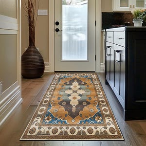 May include: A rectangular rug with an intricate, vintage design. The rug's central pattern features brown, blue, and cream hues, framed by a border of floral and geometric patterns. It is placed on a wooden floor, adding warmth to the space.