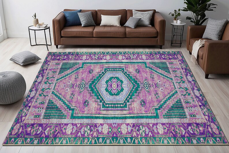 May include: A colorful rug with a geometric pattern in shades of pink, purple, green, and white. The rug has a distressed look and a fringed edge.