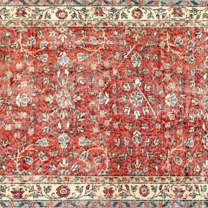 May include: A vintage red rug with a floral pattern. The rug has a cream-colored border with a blue and cream floral design.