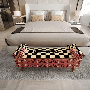 a modern bedroom with a large bed, a checkered bench, and a white headboard. The bed has a gray comforter and a black and white checkered pattern on the bench. The room has a neutral color scheme with gray walls and a gray rug.