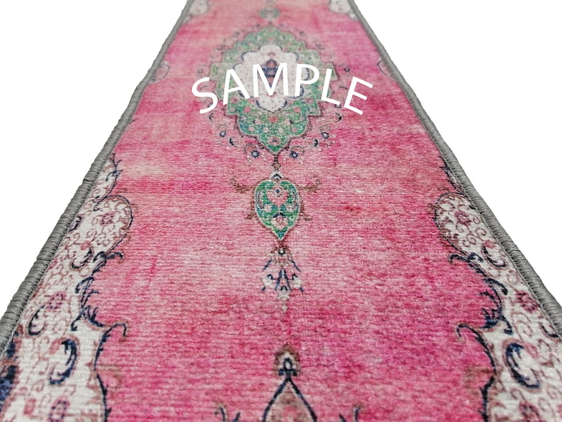 May include: A pink and white patterned rug with a grey border. The rug has a floral design with green accents. The word "SAMPLE" is printed in white on the rug.