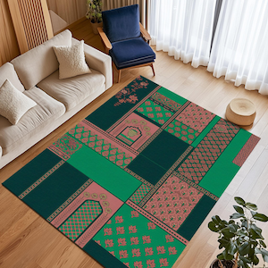 Könnte beinhalten: Ein rechteckiger Teppich mit einem Patchwork-Design in Grün- und Rosatönen. Der Teppich weist verschiedene geometrische und florale Muster auf und schafft einen lebendigen und dekorativen Bodenbelag. Der Teppich liegt auf einem Holzboden.