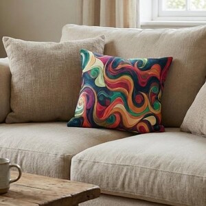 Peut inclure: Un coussin carré décoratif arborant un motif abstrait multicolore composé de formes ondulées et tourbillonnantes dans des tons de bleu profond, orange, rouge, jaune et vert sur un fond sombre, posé sur un canapé aux tons neutres.