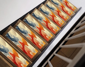 May include: A set of seven framed abstract paintings with a layered, flowing design in shades of blue, orange, and yellow. The paintings are displayed on a wooden wall shelf.