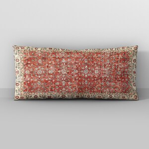 May include: A rectangular cushion with a red, white and blue floral pattern. The cushion has a cream-coloured border with a floral design.