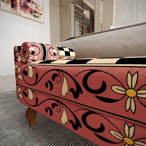 a colorful, patterned sofa with a floral design in pink, black, and white.