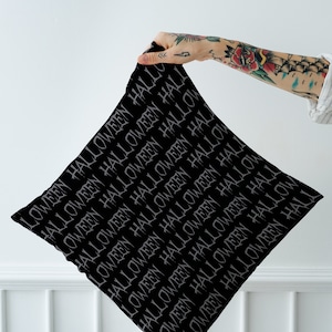 Puede incluir: Funda de almohada negra con un patrón repetido de la palabra "Halloween" en fuente gris.