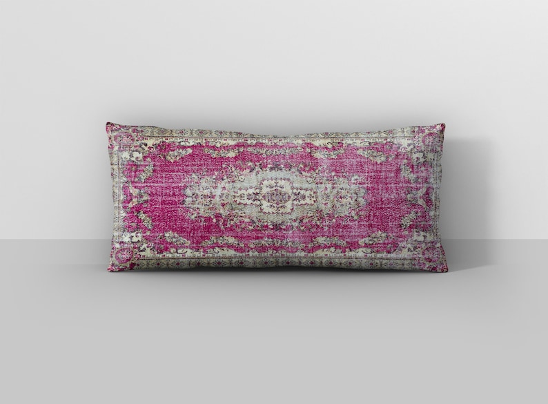 May include: A pink and cream patterned throw pillow with a vintage rug design.