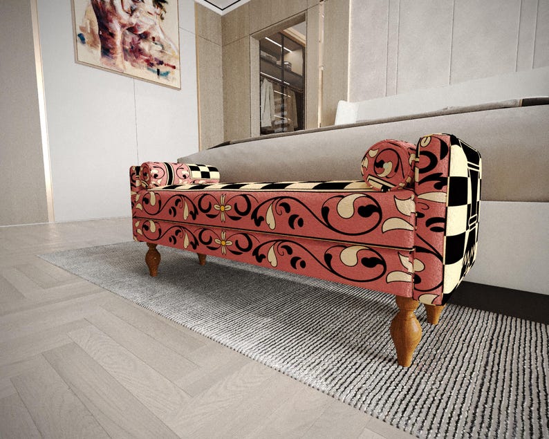 a modern, colorful bench with a floral pattern on the upholstery, placed on a gray rug in a room with a white wall and a painting.