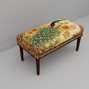 May include: A rectangular bench with a peacock design. The seat features a cream-colored background with a peacock, roses, and floral patterns. The legs are dark brown. The bench is a decorative furniture piece.