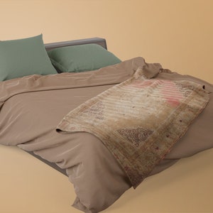 K&ouml;nnte beinhalten: Ein braunes Bett mit einem Holz-Kopfteil und zwei gr&uuml;nen Kissen. Eine braune Decke ist &uuml;ber das Bett gelegt, mit einem gemusterten &Uuml;berwurf dar&uuml;ber.